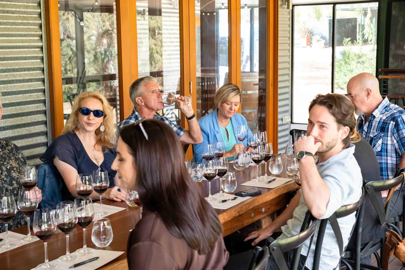 Guests seated along a winery tasting bench working through a flight of Barossa reds