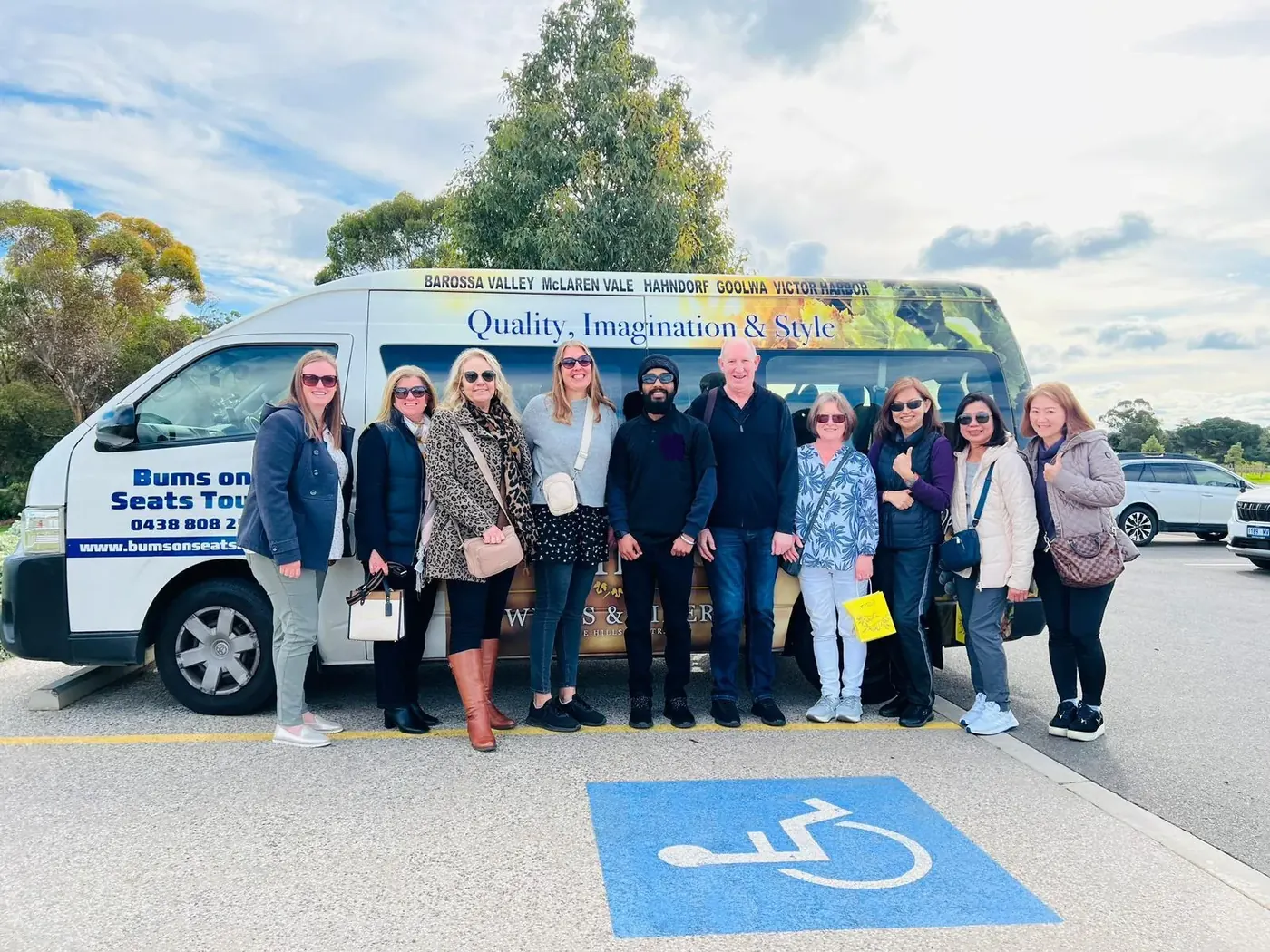 The Bums on Seats tour van with guests gathered beside it in the Barossa Valley