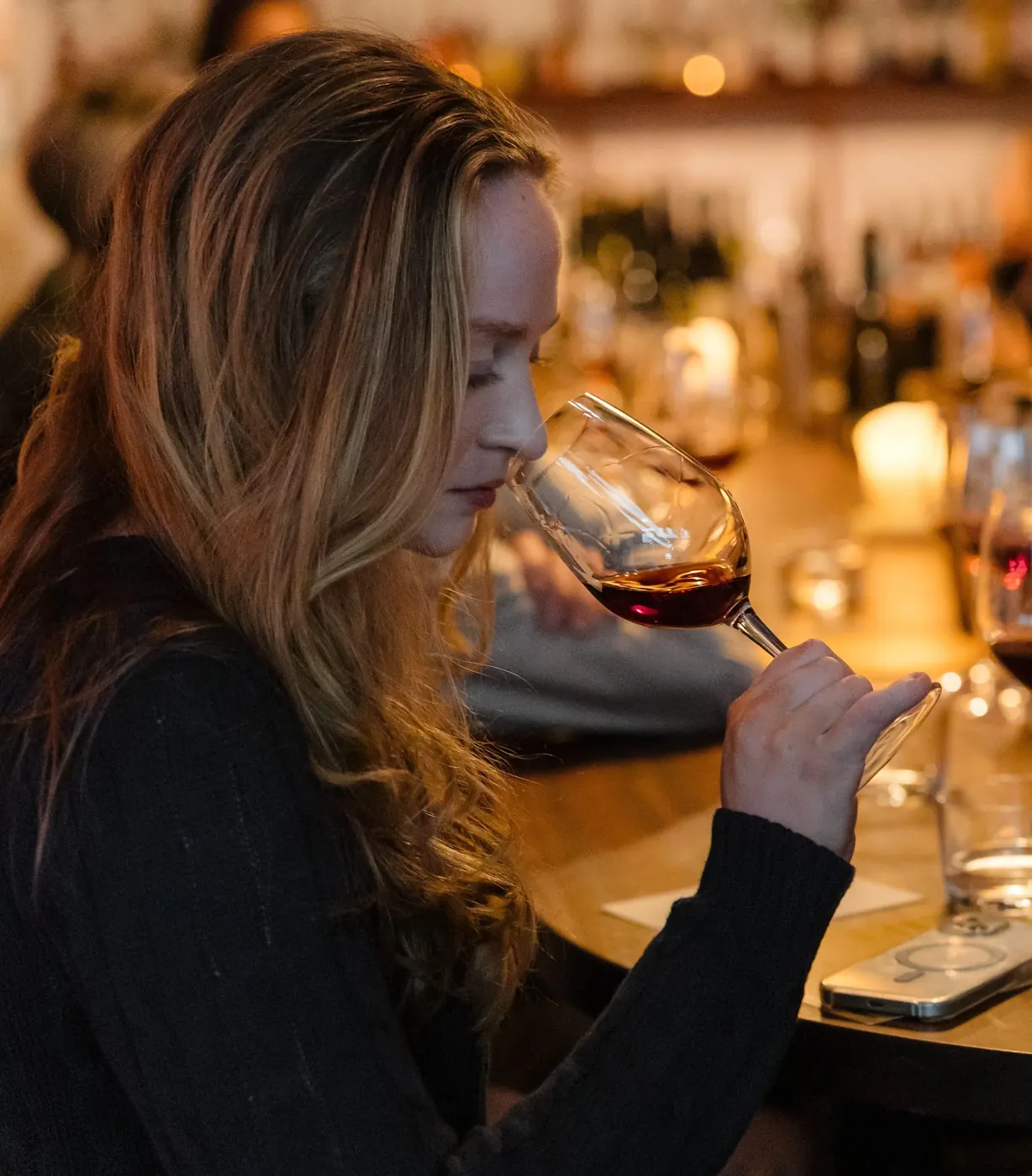 Guest nosing a glass of Barossa red in a candlelit tasting room