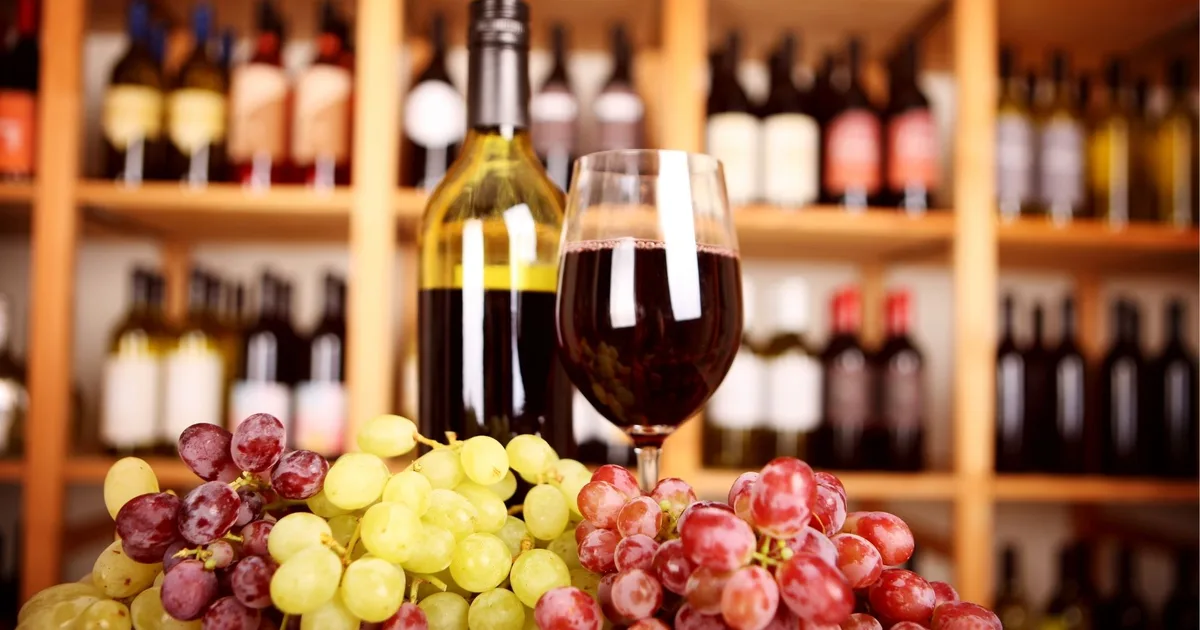 Wine glass, bottle and grapes in front of a Barossa cellar door's tasting shelves